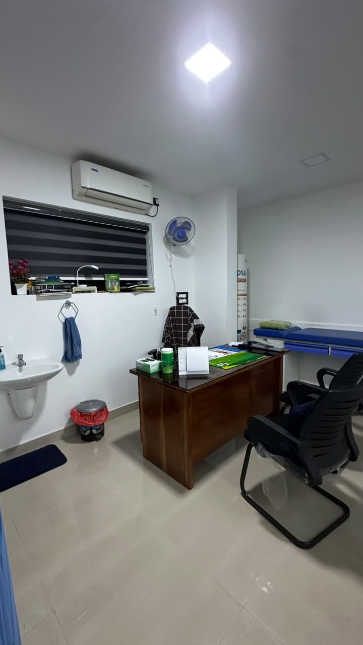 A consulting room with a desk and examination couch
