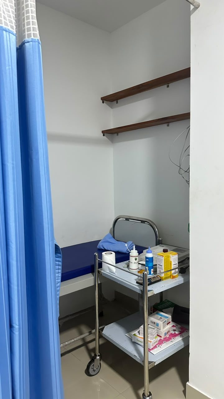 Treatment room with a bed and dressing trolley